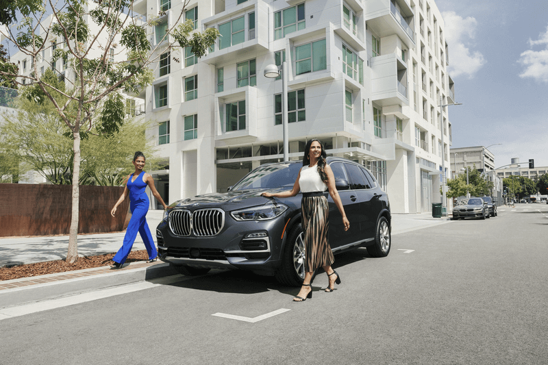 Two Women Walking Away from BMW X5