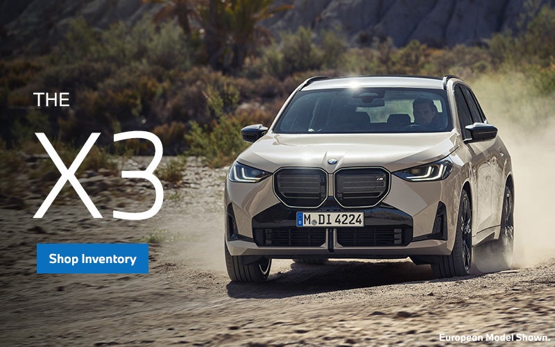 BMW X3 driving on dirt orad parked with a forest landscape. | BMW of Spokane in Spokane WA